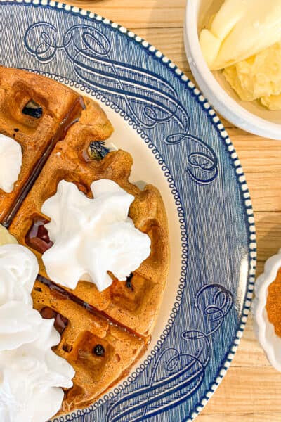 pumpkin spice waffles with syrup and whipped cream