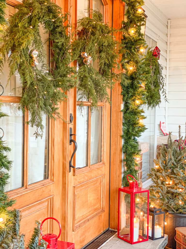 two fresh evergreen wreaths with lights, bells and red lanterns.